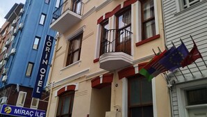 A multi-story building with balconies, a visible hotel sign, and flags. - Lorin Otel (Istanbul)