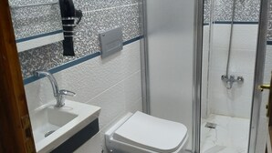 A bathroom with a sink, toilet, and shower. - Lorin Otel (Istanbul)