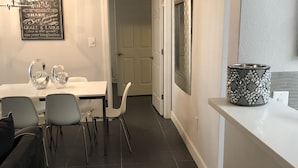 A modern kitchen with dark tiles, a white countertop, and a decorative vase.