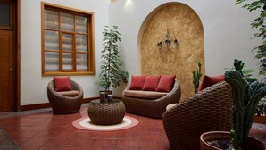 A cozy indoor seating area with wicker furniture and a potted plant.