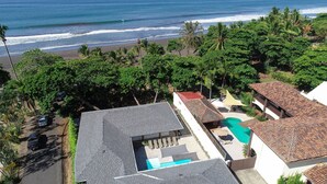Zona residencial con piscina, vista al mar y una calle con coches aparcados.