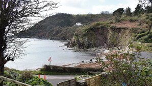 A coastal path with a wooden staircase leading down to a beach.