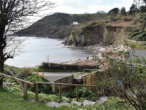 A coastal path with a wooden staircase leading down to a beach.