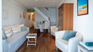Un salon moderne comprenant un canapé, une table basse et un coin repas avec des chaises et une table.