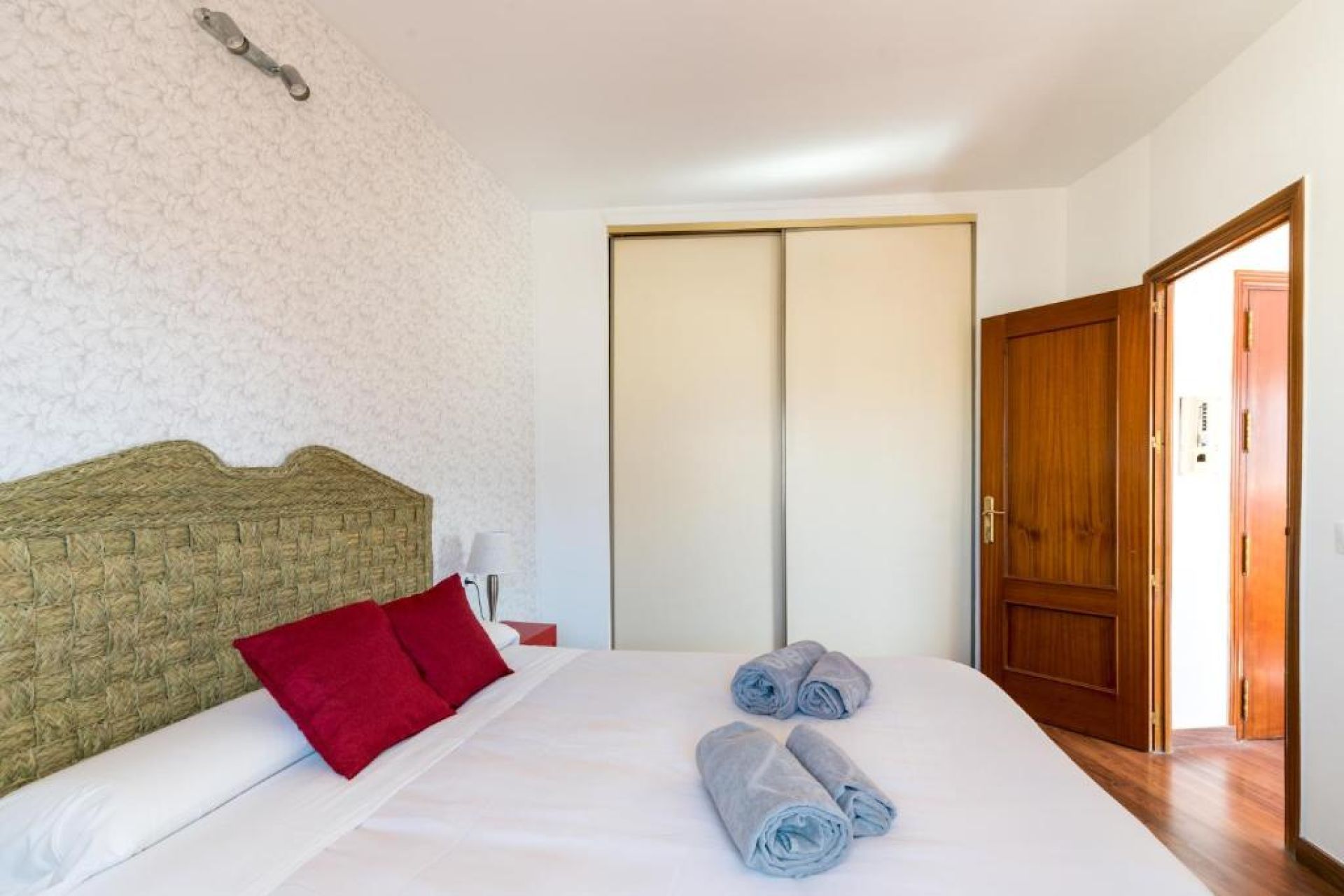 A hotel room with a bed, a wardrobe, and a door.