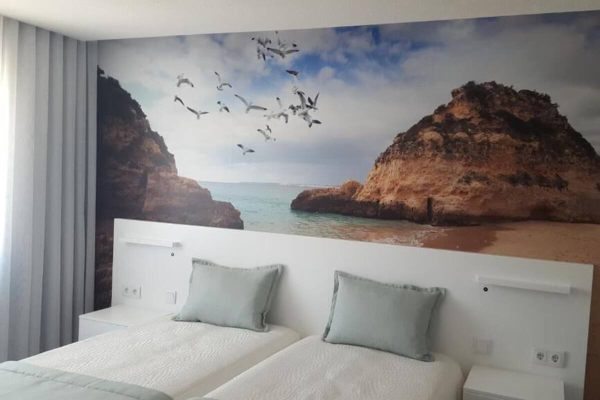 A bedroom with a large bed, two pillows, and a headboard.