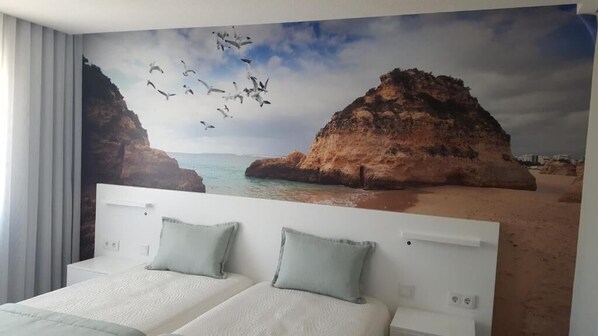A bedroom with a large bed, two pillows, and a headboard. - Golden Beach Guesthouse (Faro)