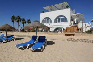 On the beach, white sand, sun loungers, beach umbrellas