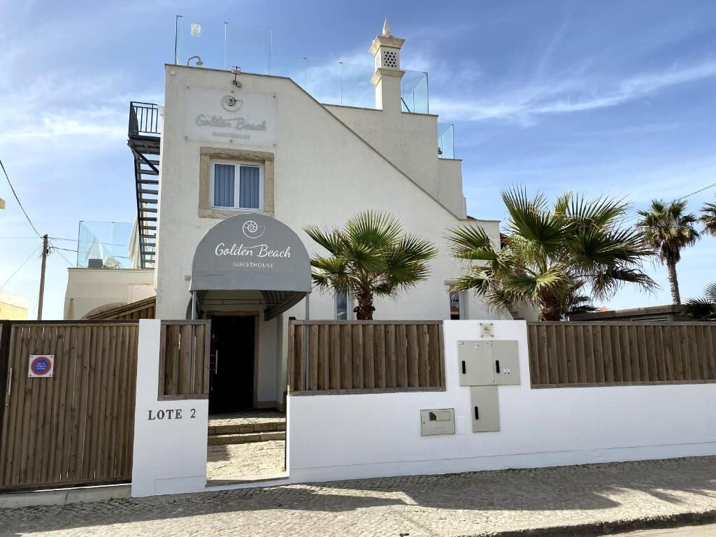 A building labeled "Golden Beach Guesthouse" with a sign indicating "Lote 2."