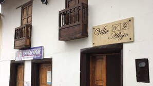 Um edifício com duas portas de madeira e uma placa que diz 'Villa Alegre'.