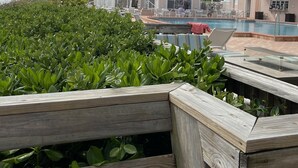 A resort with a pool, wooden deck, and buildings with balconies.