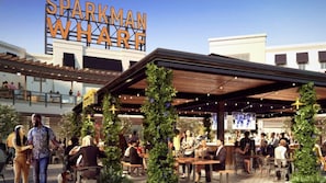 Enjoy a casual meal under the stars at Sparkman Wharf's outdoor dining area, surrounded by lush greenery and twinkling lights.