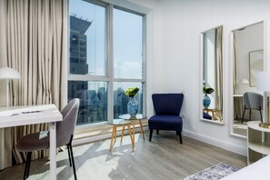 Enjoy a city view from the large window, a comfortable seating area, and a spacious desk in this stylish room.