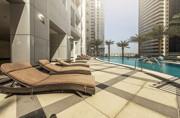 Relax by the pool surrounded by a geometric design and lounge chairs.