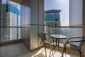 Relax on the balcony with a glass table and two chairs, taking in the city views.