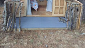 A small wooden cabin with a loft bed, a window, and a door. - The pines 4  x private chalets (Cheviot)