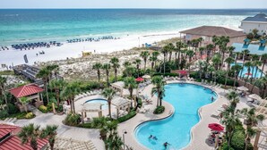 Un resort con piscina, playa y palmeras.