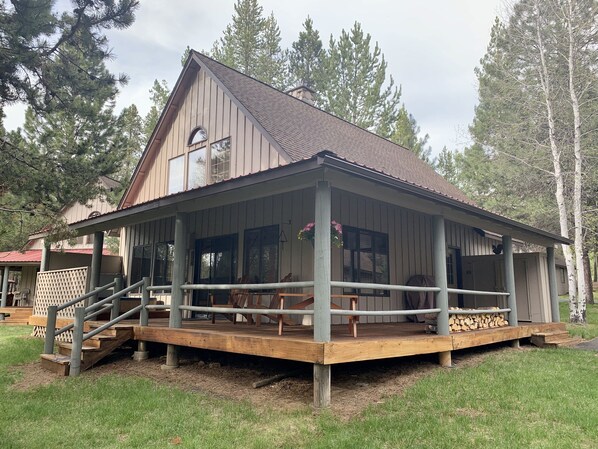 A wooden cabin with a porch, a staircase, and a deck area. - Cozy home in heart of Sunriver w/ hot tub, close to Mt Bachelor (Sunriver)