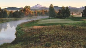 A golf course with a flag, a lake, and a mountain in the background. - Cozy home in heart of Sunriver w/ hot tub, close to Mt Bachelor (Sunriver)