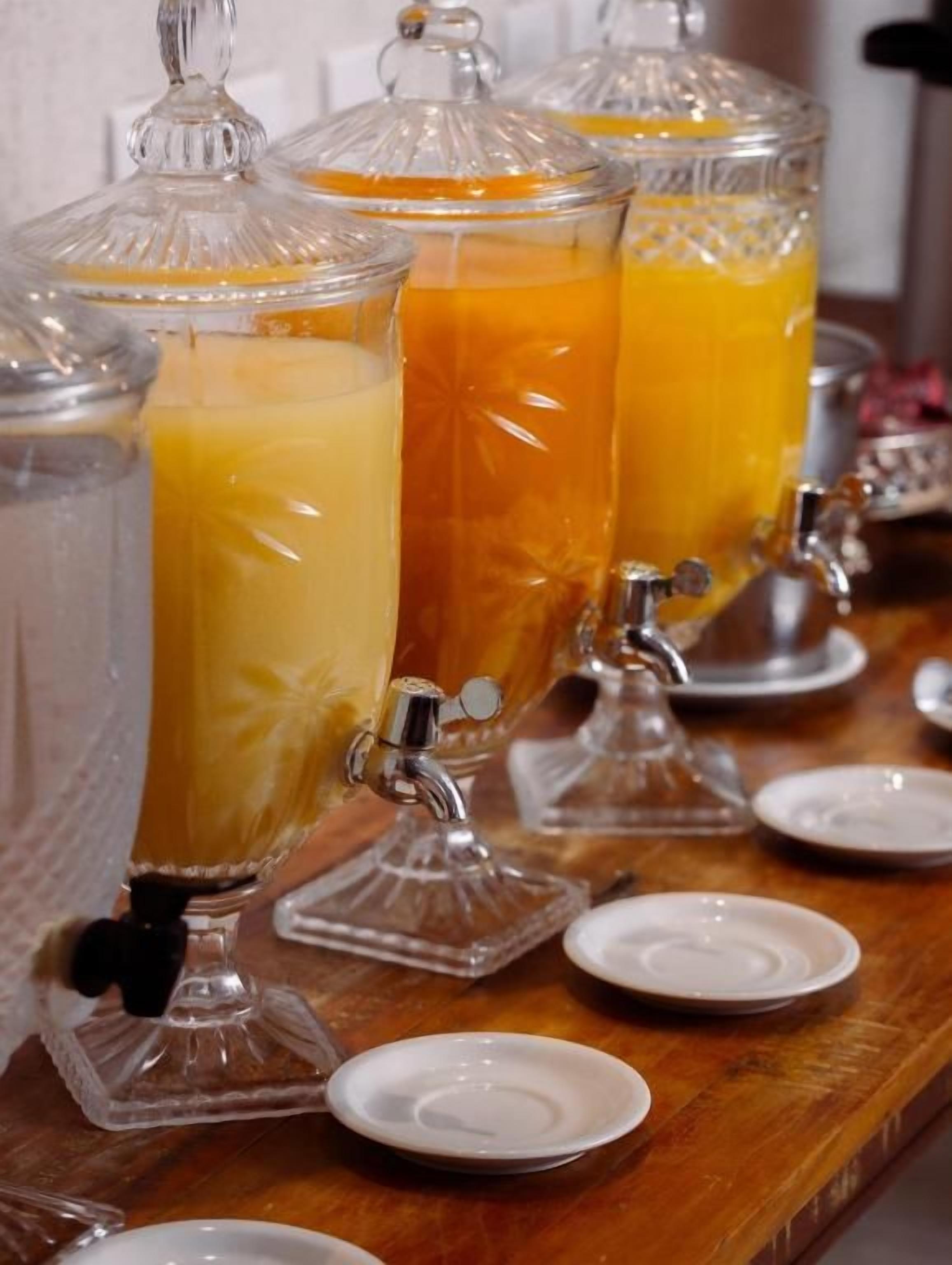 A beverage dispenser with multiple containers, each with a spout for pouring.