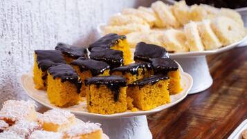 Diversos postres sobre platos de cerámica blanca dispuestos sobre una mesa de madera.