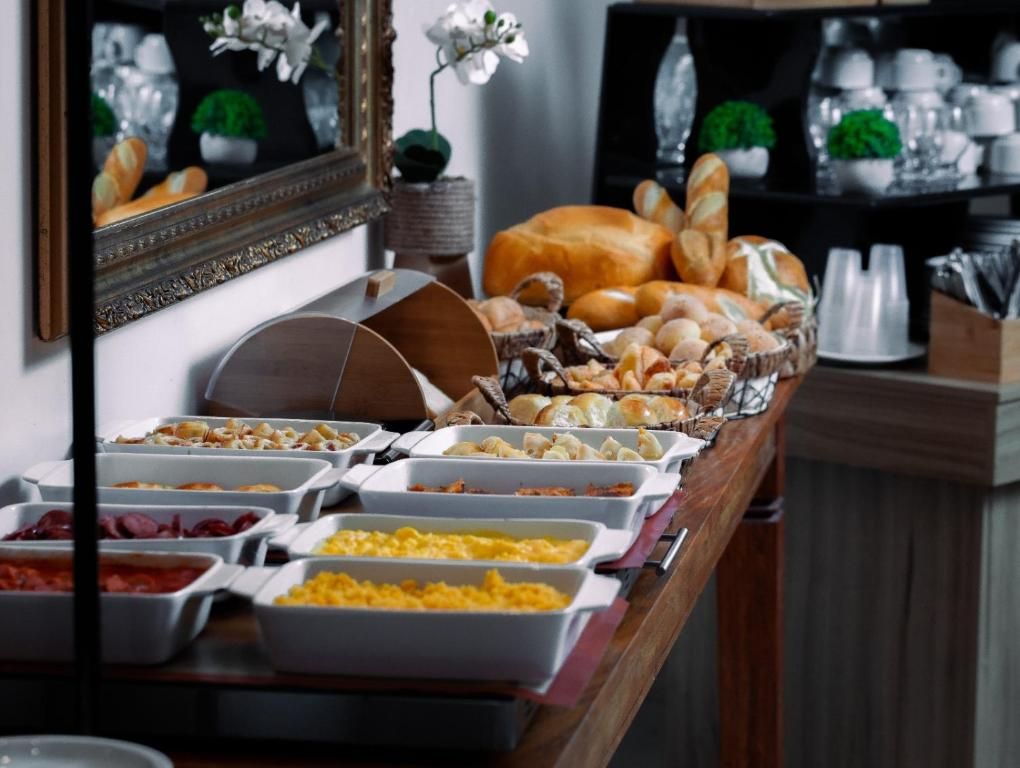 A buffet with various food items and a mirror reflecting the room.