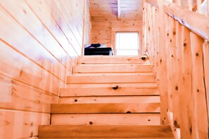A wooden staircase leading to a room with a window.