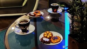 A modern living room with a glass coffee table, a sofa, and a decorative mirror on the wall. - One of a kind LUXURY Apartment in City Center Near HELEXPO (Thessaloniki)