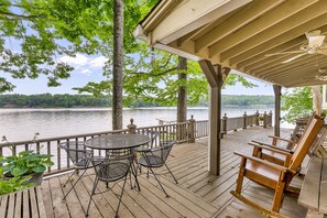 A wooden deck with a table and chairs, overlooking a lake. - Nanas Lakehouse - Private dock with Jet-ski port! (Jasper)