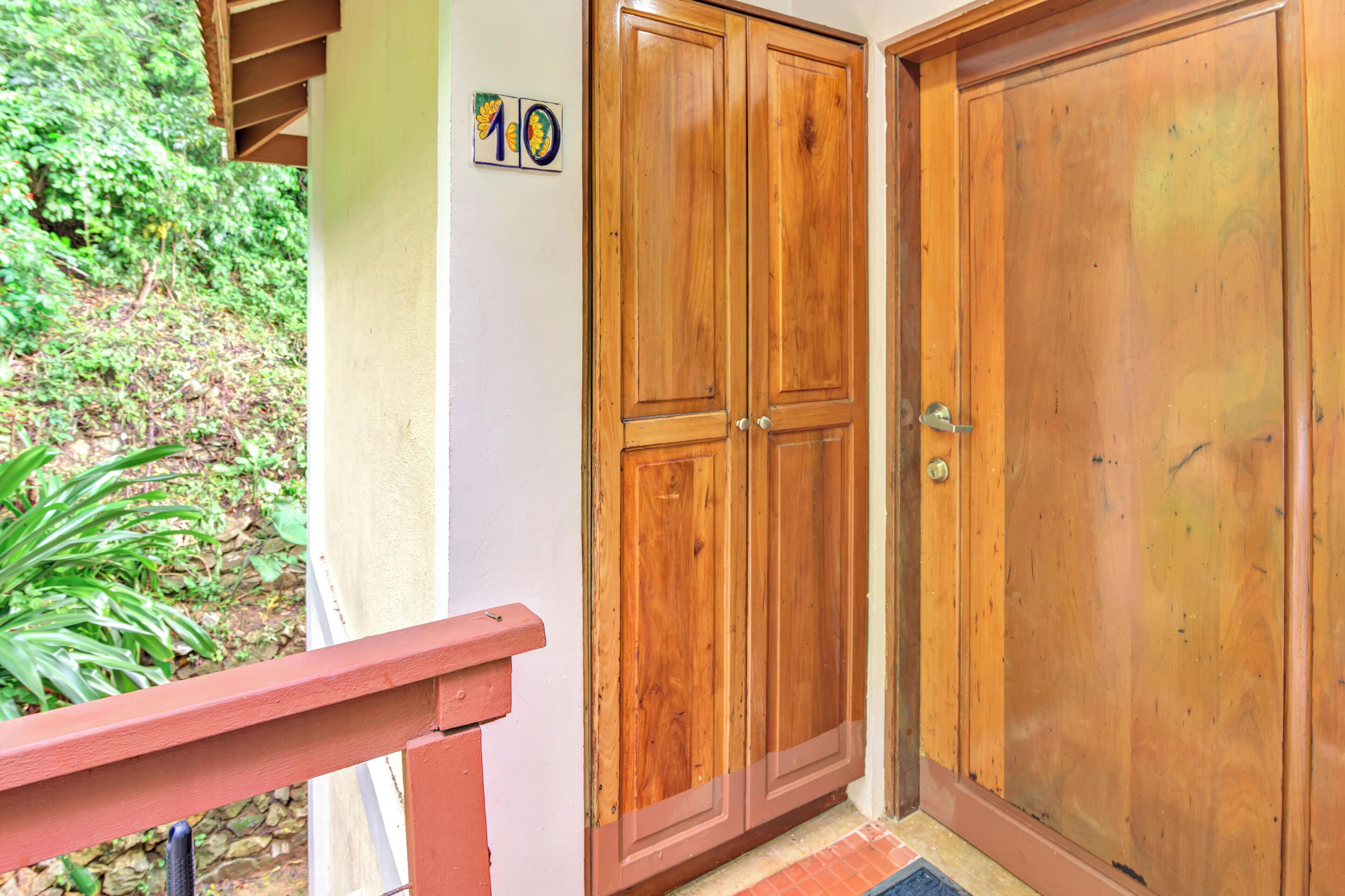 Une porte à deux battants en bois, avec un panneau portant le numéro « 10 » fixé au mur à côté.