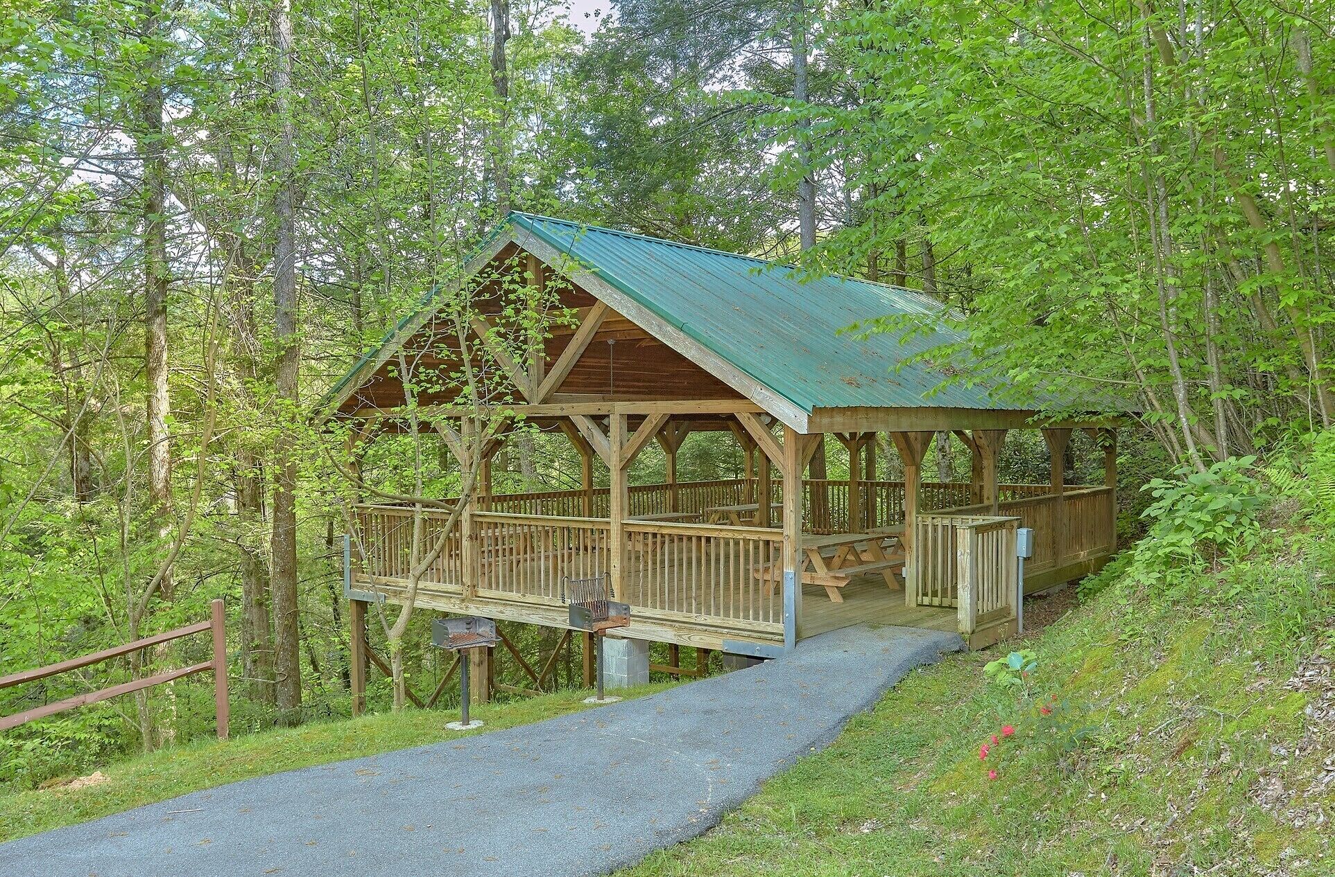 A wooden cabin with a metal roof, surrounded by trees.