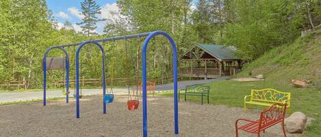 Ein Spielplatz mit Schaukeln und einem überdachten Pavillon.