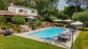 A residential property with a swimming pool, outdoor furniture, and a garden.