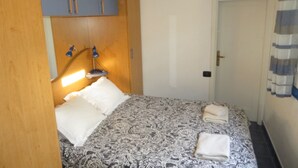 Une chambre à coucher avec un lit, une armoire en bois et une porte.