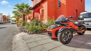 Ein rotes Gebäude mit einem abgestellten Motorrad und einem weißen Lieferwagen.