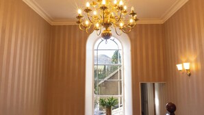 A room with a large arched window, a chandelier, and a mirror. - Newton Manor House -7 Bedroom House (Cupar)
