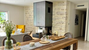 A modern dining area with a wooden table, benches, and a stone wall. - The butterflies of Quercy (Caylus)
