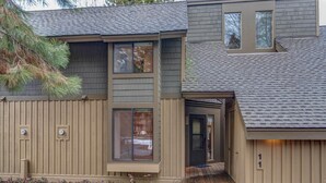 A two-story house with a front porch, a garage, and a small deck. - Quelah Condo 11 (Bend)