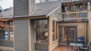 A modern house with a large deck, a covered patio, and a visible staircase leading to an upper level. - Quelah Condo 11 (Bend)