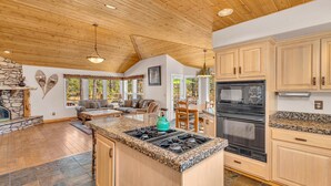 A spacious kitchen with granite countertops, a built-in stove, and wooden cabinets.