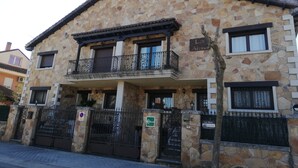 A stone building with a balcony, a gated entrance, and a sign indicating 'Los Alisos.' - Los Alisos Country House (Guadalix de la Sierra)