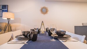 A dining table set with black bowls, wine glasses, and cutlery, with a blue table runner. - Modern 2bed2bath APT at Neutral Bayparking+wifi (Neutral Bay)