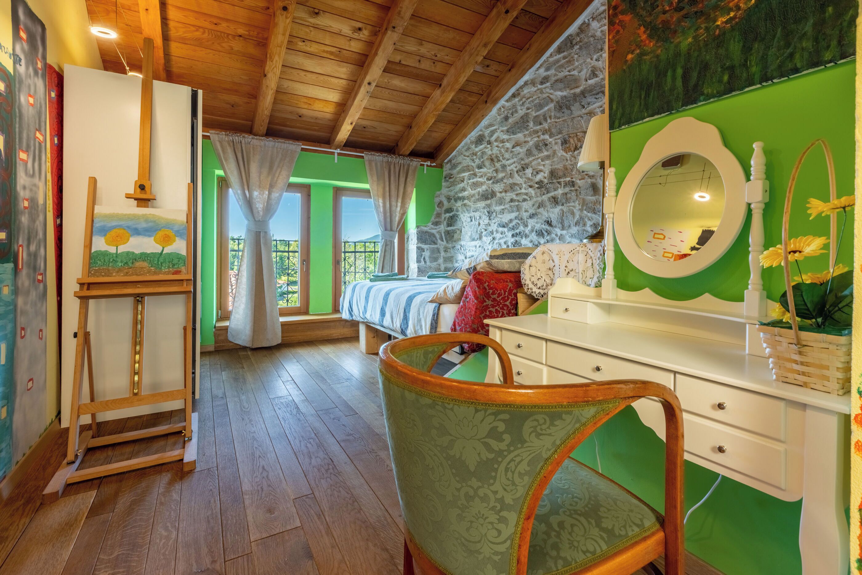 A room with a wooden ceiling, a bed with a green wall, a dresser with a mirror, and a chair.