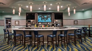 A bar area with a counter, bar stools, and a large screen displaying an underwater scene. - 1556 PD Champions Gate (Davenport)