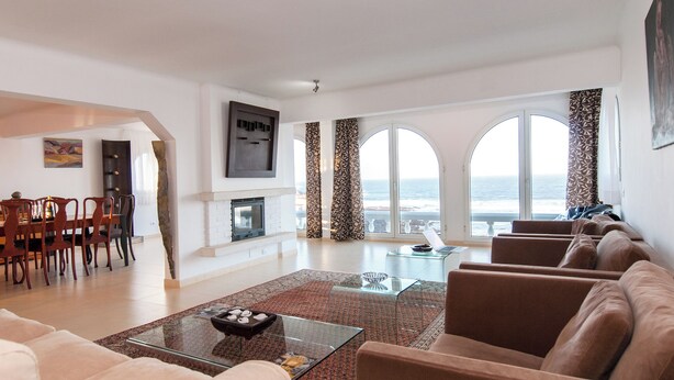 A spacious living area with a fireplace, a dining set, and a large window with a view of the sea. - Terrazas del Mar Villa on the Beach Sea Terrace Wifi Free Golf Ecological House (Telde)