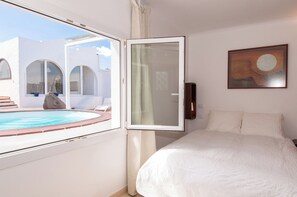 A bedroom with a bed, a painting, a view of a pool, and a white wall. - Terrazas del Mar Villa on the Beach Sea Terrace Wifi Free Golf Ecological House (Telde)