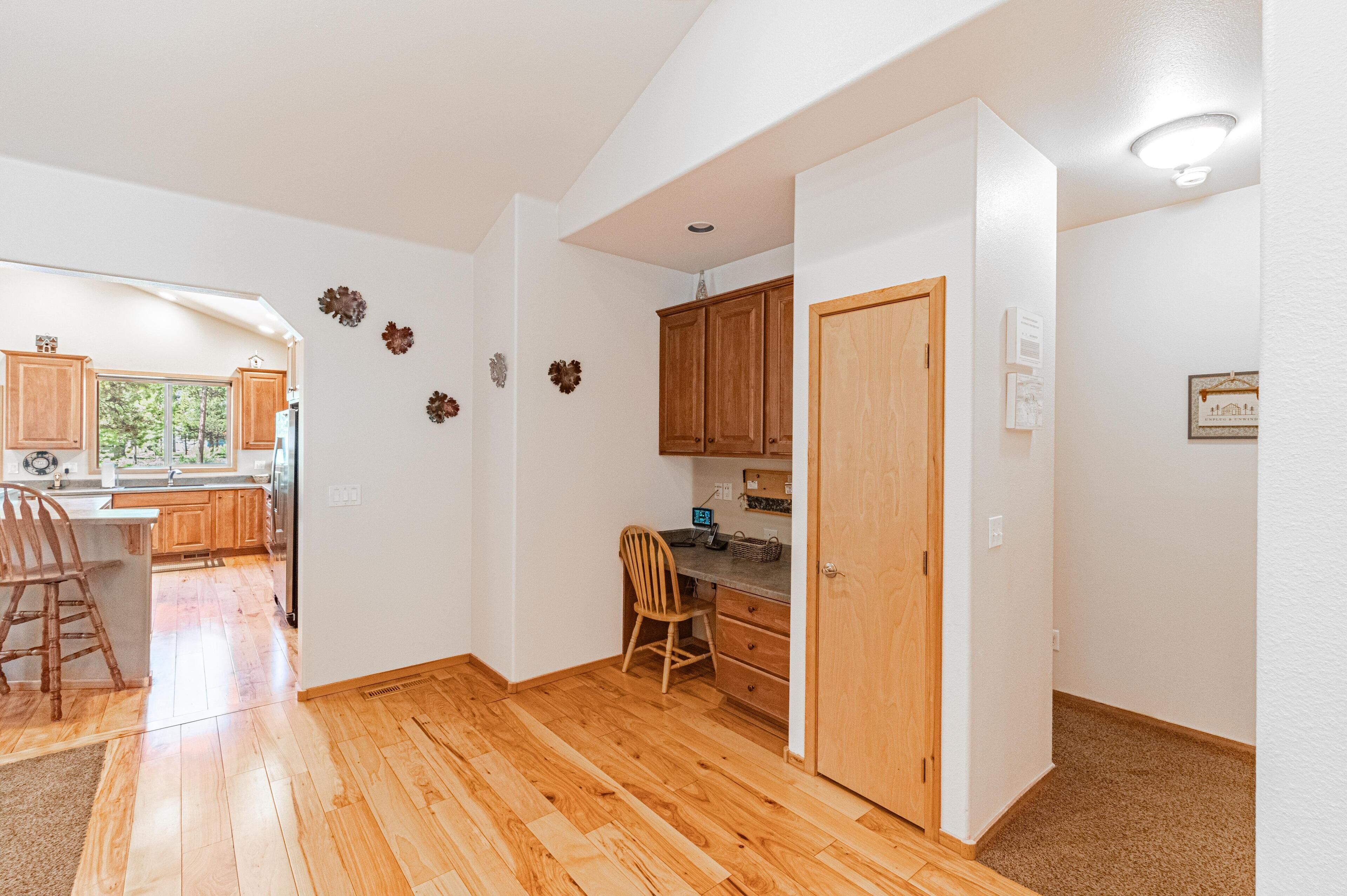 A spacious kitchen with wooden cabinets, a dining area with a wooden chair, and a view of the outdoors.