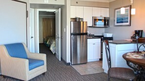 A compact hotel room with a kitchenette, a dining area, and a bed. - Caravelle Resort by Palmetto Vacations (Myrtle Beach)
