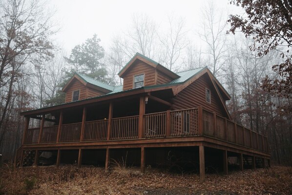A two-story log cabin with a balcony, surrounded by trees. - Log Home in a Peaceful Wood in Jim Thorpe (Jim Thorpe)