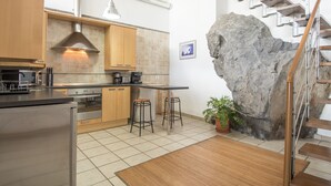 Eine moderne Küche mit Edelstahlgeräten, Holzschränken und einer großen Felsformation.